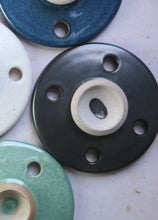 Load image into Gallery viewer, overhead photo of a black circular disc shaped ceramic cooking stone with an exposed handle
