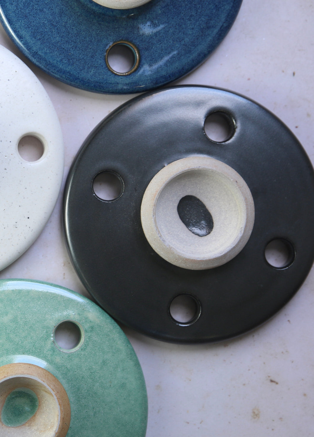 overhead photo of a black circular disc shaped ceramic cooking stone with an exposed handle